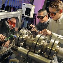 Engineers work to calibrate an optical setup.