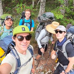 Selfie of a group of student with backpacks in a wooded setting