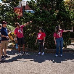 Staff in Opening Days shirts provide directions to a new student and their supporter.