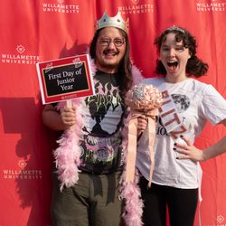 Two students posing with props and a sign that says First Day of Junior Year