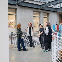 Two students and two career development staff talking in an open industrial space at Pacific Northwest College of Art. 