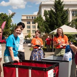 Students and staff with a wheely cart meeting new students outside Baxter Hall to help pove in.